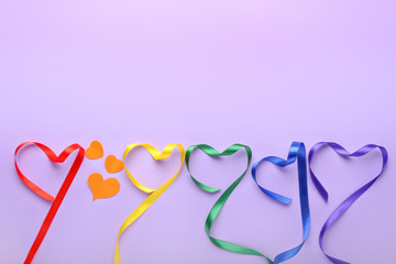 Hearts made of ribbons on color background. LGBT concept