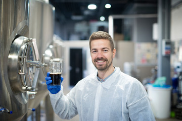 Fototapeta na wymiar Portrait of technologist testing product quality in beverage alcohol production plant.