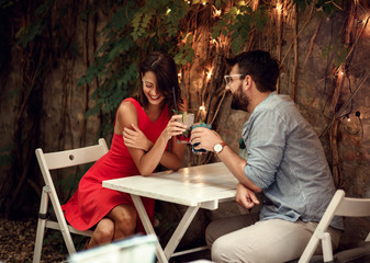 happy couple on date celebrating Valentines day.  Love and romance . elegant lovers having fun with lights in background. Valentines day concept.