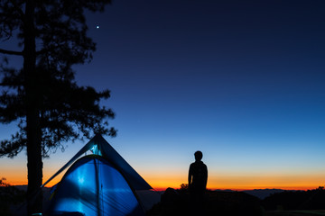 Tourists silhouette with the light of the sunset at dusk and tents to admire the beauty of nature