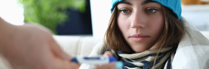 Portrait of thermal measuring utility used for finding out various sickness from common cold to severe flu. Woman in warm clothes trying cure body condition. Hard virus concept