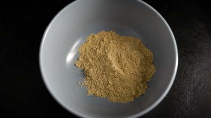 Object shooting. In the frame is a plate with ginger powder. Spice, ingredient for cooking.