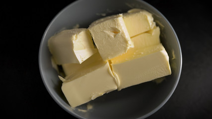 Ingredients and products in the kitchen. Butter is cut into pieces. Fresh foods are important for good food.