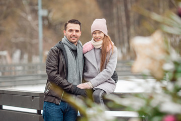 Obraz premium Young dad and adorable little girl have fun on skating rink outdoors