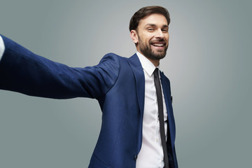 wide angle selfie shot of young handsome stylish businessman wearing suit