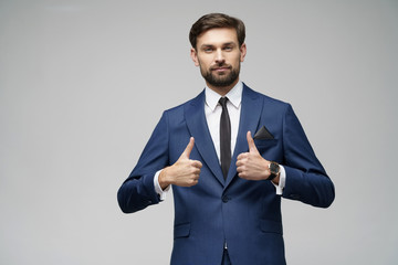 young business man going thumb up on grey background