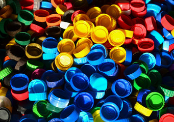Plastic bottle caps background. Cap material is recyclable.Remove lids from plastic bottles before recycling them. Recycling collection and processing plastic bottle caps