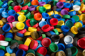 Plastic bottle caps background. Cap material is recyclable.Remove lids from plastic bottles before recycling them. Recycling collection and processing plastic bottle caps