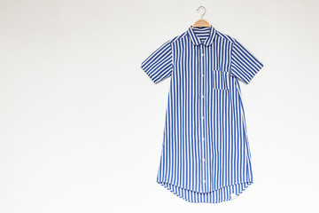 Blue colour dress is clothes hanger on white background.