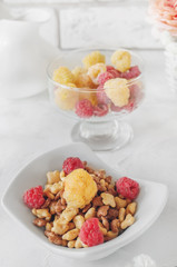 Organic granola with raspberries for Breakfast in a white porcelain Cup on a light background