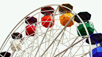 Part of the ferris wheel with open colored cabins on top of the ride