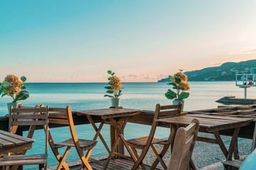 View of the coastline. Wooden tables and chairs on the waterfront by the sea. Massandra beach, Yalta, Crimea