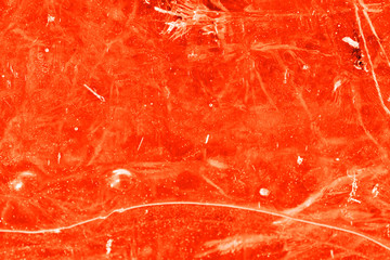Dry grass under transparent ice close-up. Natural abstract background orange color toned