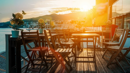 View of the coastline. Wooden tables and chairs on the promenade by the sea at sunset. Massandra beach, Yalta, Crimea