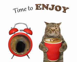 The beige cat with a paper cup of black coffee is standing near a big red alarm clock. Time to enjoy. White background. Isolated.