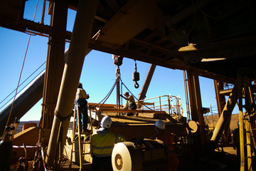 Rigger wearing a fall safety helmet, harness protection conducting final safety inspection on crane...