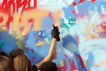 young people draw graffiti on the wall of the building