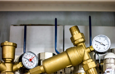 Closeup of a water pressure meter and pipes on a counter in a store