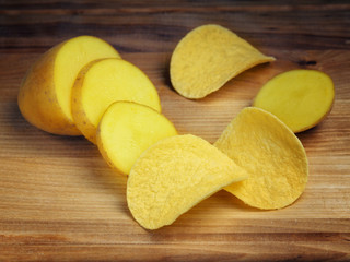 Sliced Potato Tuber and Potato Chips on a Wooden Surface