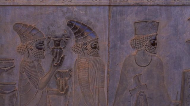Panning right | Bearded Men Relief | Ancient ruins of Persepolis near Shiraz, Southern Iran. This walls's relief shows many things in the past of Persian empire | Silk Road Iran
