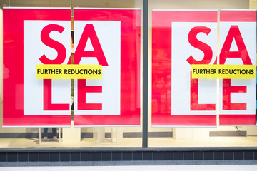 Closing down sale sign with further reductions and discount in shop store mall window