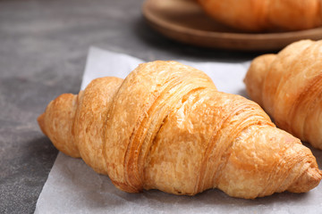 Tasty fresh croissants on grey table, closeup