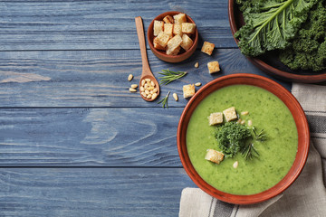 Tasty kale soup on blue wooden table, flat lay. Space for text