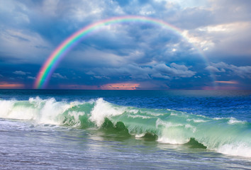 Rainbow over the stormy sea after rain