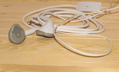 white mini earphones on wooden background