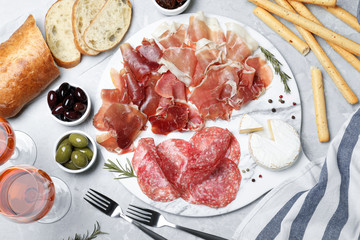 Tasty prosciutto served on light grey marble table, flat lay