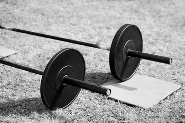 Obraz na płótnie Canvas Cross-fit lifting bar. Cross-fit training. Sports, cross-fit and fitness concept. Monochrome photography 