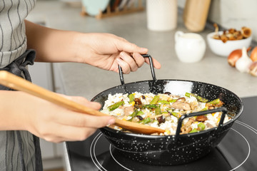 Woman cooking delicious risotto, closeup. Tasty recipe