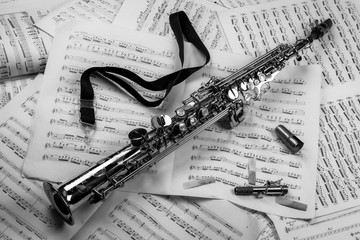 Soprano saxophone lying on a background of musical notes (balck and white)