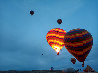 Colorful Hot Air Balloons flying over Cappadocia early morning at winter with dark morning in Turkey