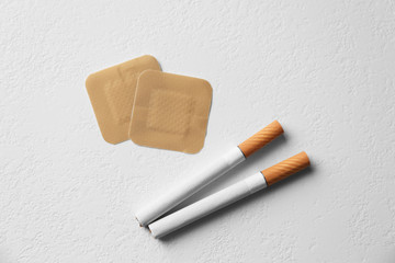 Nicotine patches and cigarettes on white background, flat lay