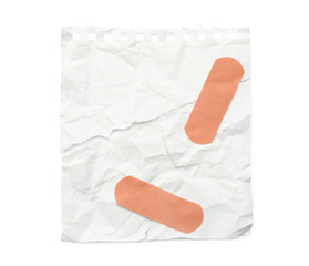Crumpled paper with sticking plasters isolated on white, top view