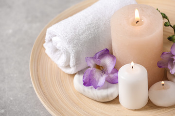 Plakat Beautiful composition with spa stones and burning candles on grey table, closeup