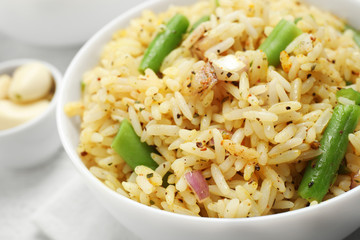 Tasty rice pilaf with vegetables on table, closeup
