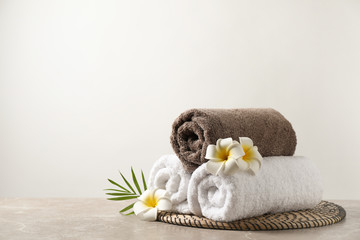 Beautiful spa composition with plumeria flowers on grey marble table against light background....