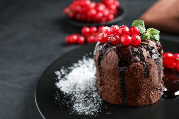 Delicious warm chocolate lava cake with mint and berries on table, closeup. Space for text