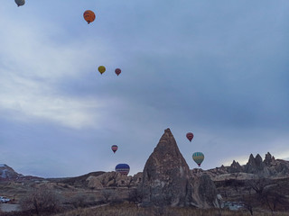 Fototapeta na wymiar Colorful Hot Air Balloons flying over Cappadocia early morning in winter in Turkey