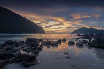 view seaside evening of many arch rocks in the sea with yellow sun light and cloudy sky background, sunset at Khao Chong Kad, Mu Ko Surin island, Phang Nga, southern of Thailand.