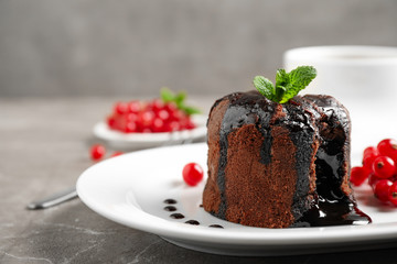 Delicious warm chocolate lava cake with mint and berries on marble table, closeup. Space for text