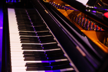 Obraz na płótnie Canvas Electric piano close up, black and white piano keys, blue light on piano keyboard, yellow light