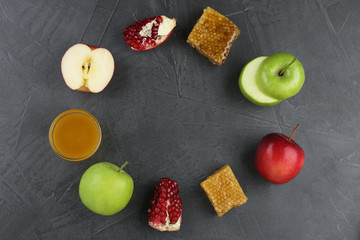 Flat lay composition with honey and fruits on grey table, space for text. Rosh Hashanah holiday