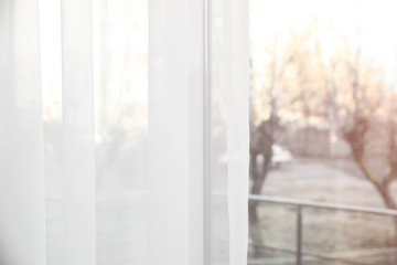 Fototapeta na wymiar Window with white curtains indoors, closeup view