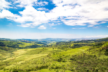 Fototapeta na wymiar Panoramic view over a green and vast valley on a sunny day, Drakensberg, Giants Castle Game Reserve, South Africa