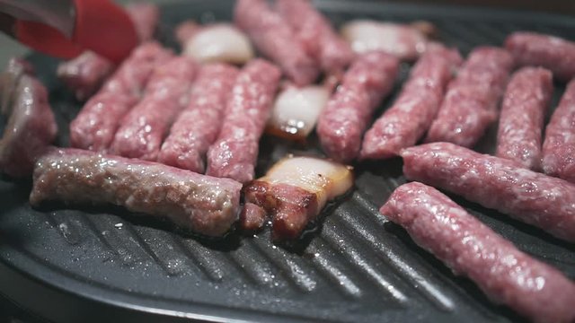Grilling kebabs and bacon, delicious meat, indescribable aroma. Pan left to right.