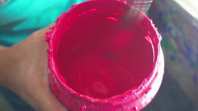 Worker hand mixing ink paint for silk screen printing use at Garment Manufacturers.