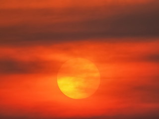 view evening of big yellow sun around with dark clouds with orange sun light in the sky background, sunset at Surin island, Phang Nga, southern of Thailand.